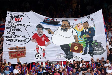 FA investigating Palace banner showing Forest owner Marinakis with gun to Gibbs-White’s head, as Forest condemn it as inflammatory and xenophobic.