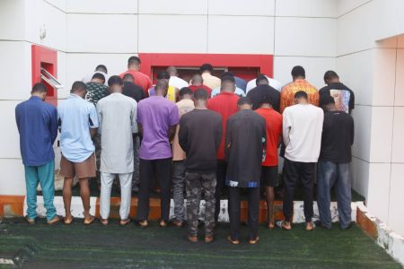 EFCC operatives display cars, laptops, and phones recovered from suspected internet fraudsters arrested in Ilorin.