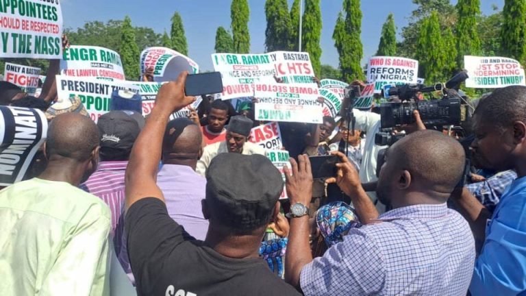 Protesters outside Nigeria’s National Assembly demand Senate confirmation of Abdullahi Ramat as NERC chairman, holding placards and chanting solidarity songs.