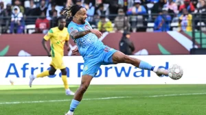 Bongonda volley hands DR Congo narrow AFCON win **Bongonda Volley Hands DR Congo Narrow AFCON Win** DR Congo began their Africa Cup of Nations 2025 campaign with a hard-fought 1-0 victory over Benin in Group D, as Theo Bongonda’s early strike proved enough to secure three valuable points in Rabat. In a tense encounter at the compact Stade El Barid, the Leopards showed flashes of their pedigree as recent semi-finalists, but also revealed familiar wastefulness in front of goal that could yet haunt them against stronger opposition. The decisive moment arrived in the 16th minute. Arthur Masuaku launched a long ball forward from the left, and a moment of hesitation in the Benin defence proved costly. Centre-back Yohan Roche ducked under the delivery, allowing Bongonda to stretch out his left foot and guide a first-time volley into the bottom right corner from close range. It was a goal born as much from Benin’s miscommunication as from Bongonda’s sharp anticipation. That strike settled DR Congo nerves and gave them control of the contest, though they were unable to fully capitalise on their dominance. Cedric Bakambu, leading the line, was central to most of their attacking play and could easily have finished the game as the tournament’s early top scorer. Shortly after the interval, Bakambu thought he had doubled the lead with a close-range header, only for celebrations to be cut short by a lengthy VAR review. The goal was eventually ruled out for an infringement in the build-up, to the frustration of the Leopards’ bench. The former Villarreal striker then found himself clean through on goal, but Benin goalkeeper Saturnin Allagbe stood tall to deny him in a one-on-one. Moments later, Bakambu spurned another golden chance when he headed straight at Allagbe from a well-delivered free-kick. Each miss kept Benin alive and added tension to the closing stages. Despite enjoying decent spells of possession, Benin struggled to turn the ball into clear opportunities. Managed by former Nigeria coach Gernot Rohr, the Cheetahs were playing their first Afcon match since 2019 and were missing key attacking options, including forward Junior Olaitan. Their build-up play was neat at times, but too often lacked incision in the final third. They came agonisingly close to an equaliser in the final minute of normal time. Substitute Aiyegun Tosin broke into the box from a tight angle and fired a shot that struck the legs of DR Congo goalkeeper Lionel Mpasi before bouncing across the face of goal and away to safety. It was Benin’s clearest chance of the night and one that left their supporters with hands on heads. The second half was also disrupted by technical issues with the referee’s communications equipment, contributing to a lengthy 10 minutes of added time. Under sustained late pressure, DR Congo defended resolutely, showing the organisation and composure that took them to the semi-finals at the last tournament in Ivory Coast. The win continues a strong run of form for Sebastien Desabre’s side, who arrived in Morocco buoyed by recent World Cup qualifying play-off victories over Cameroon and Nigeria. However, the profligacy on display will concern the coach ahead of tougher tests to come. Benin, meanwhile, will look to regroup quickly. They are set to benefit from the return of experienced striker Steve Mounie in their next group match against Botswana, a fixture that already feels crucial for their qualification hopes. For DR Congo, attention now turns to a heavyweight Group D clash against two-time champions Senegal in Tangier. With three points already in the bag, the Leopards have made the perfect start on paper, but improvements in front of goal will be essential if they are to go deep into the tournament once again.