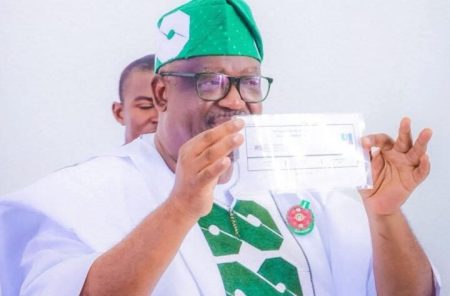 Governor Caleb Mutfwang displaying his APC membership card in Jos.