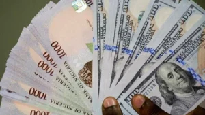 Naira gains nearly N100 against dollar in 2025 as Nigeria’s foreign reserves rise by $4.6bn Nigerian naira banknotes and US dollar bills symbolising the naira’s appreciation and rising foreign reserves in 2025.