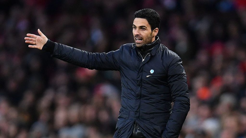 Mikel Arteta on the touchline during an Arsenal match, rallying his players amid a tight Premier League title race.