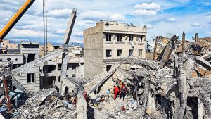 Rescue workers searching rubble of a bombed residential building in Tehran following airstrikes amid U.S.-Iran conflict.